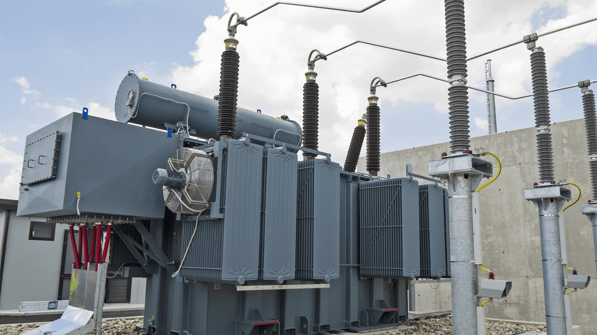 A bank of industrial electrical transformers with safety measures.